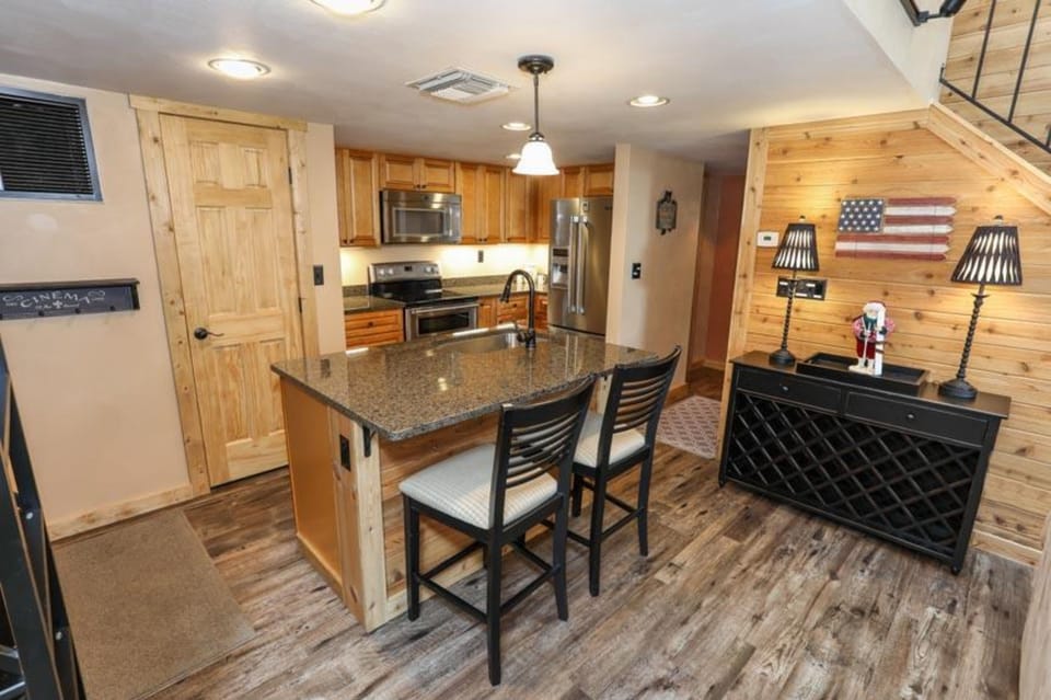 Charming kitchen with wood accents, modern appliances, and breakfast bar for casual dining or morning coffee.