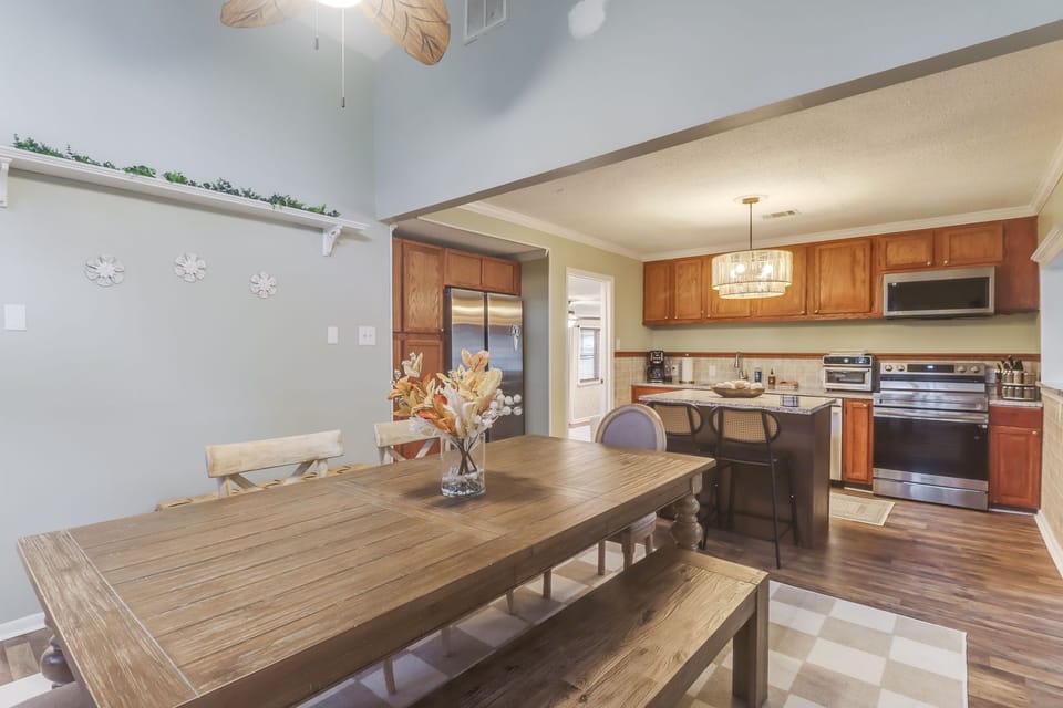 Step into the heart of the home where the cozy dining table meets a modern kitchen outfitted with stainless steel appliances, ready for your culinary adventures.