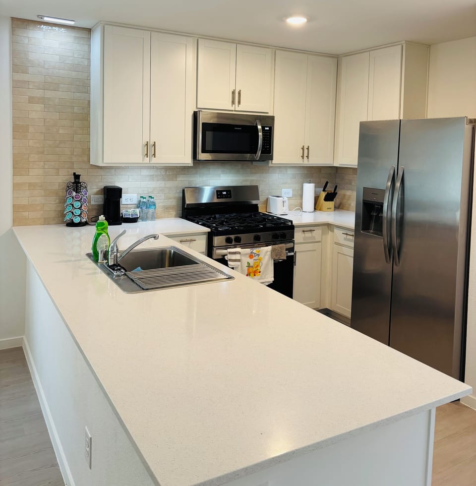 Full kitchen with a stove, microwave and refrigerator.