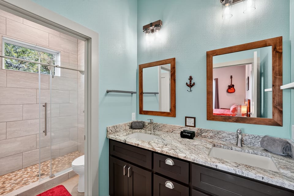 Bathroom with a double-sink vanity and an adjacent walk-in glass shower.