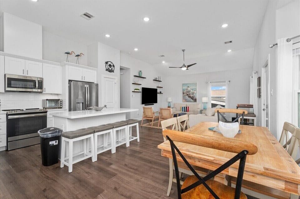 Open dining and kitchen area with large farmhouse table and modern finishes.