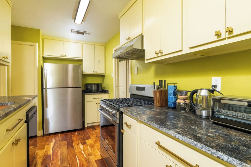 Bright, fully equipped kitchen w/ stainless steel appliances & warm wood floors
