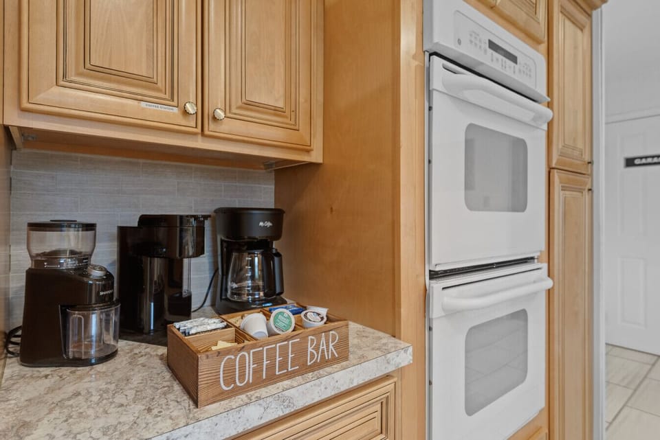 Kitchen | Spacious and bright with wood cabinetry, modern appliances, and island seating.