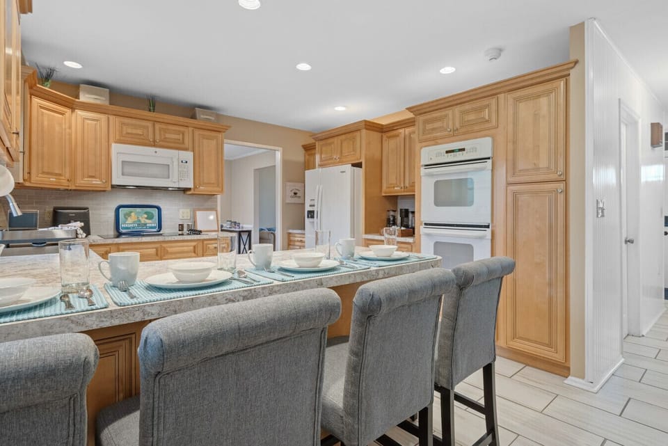 Kitchen | Spacious and bright with wood cabinetry, modern appliances, and island seating.