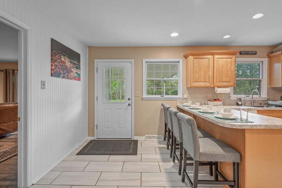 Kitchen | Spacious and bright with wood cabinetry, modern appliances, and island seating.