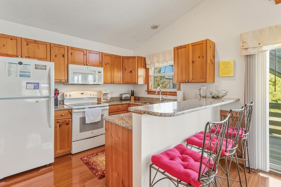The breakfast bar offers casual seating for quick meals, morning coffee, or conversation with the cook while enjoying the bright, open kitchen.