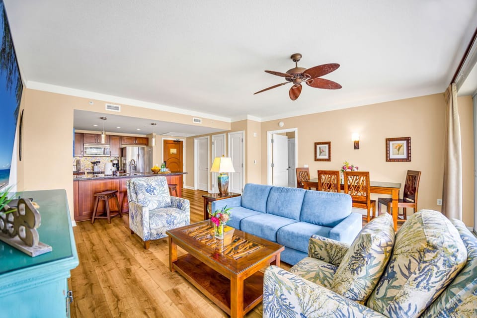 Spacious living room blends comfort and function with ample seating and tropical-themed design.