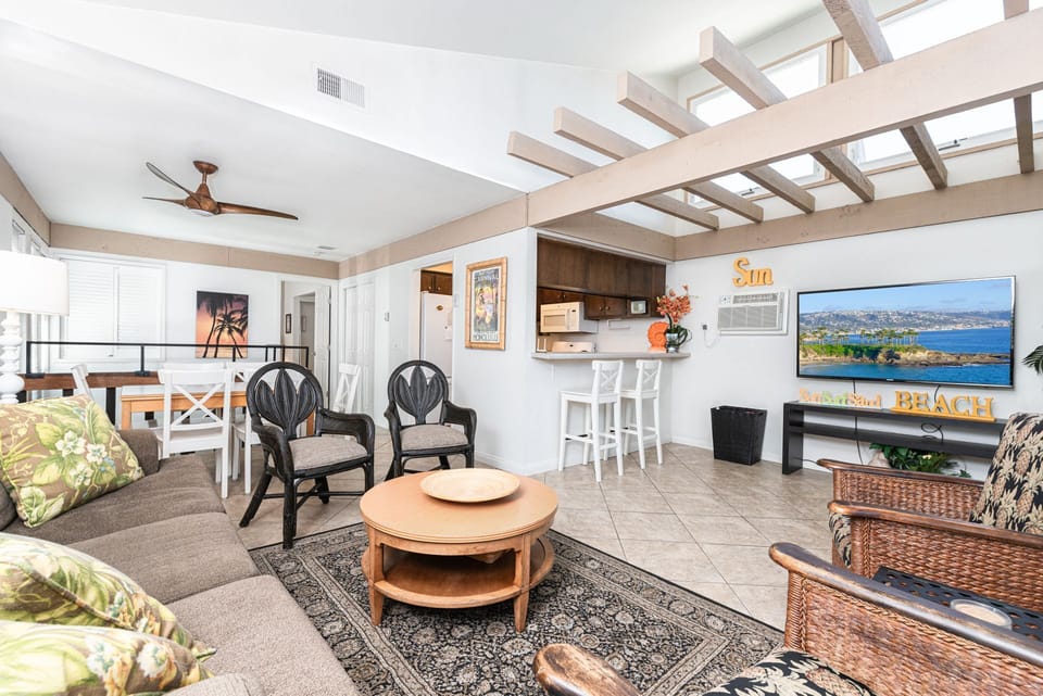 Stairs lead up to the main level, where you'll find a sofa, additional seating, cable TV, and the kitchen just beyond
                