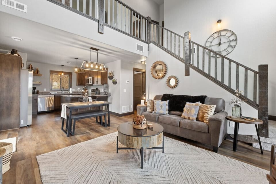 The focal point is the impressive, wide stone and wood-clad fireplace, perfect for cozy evenings.