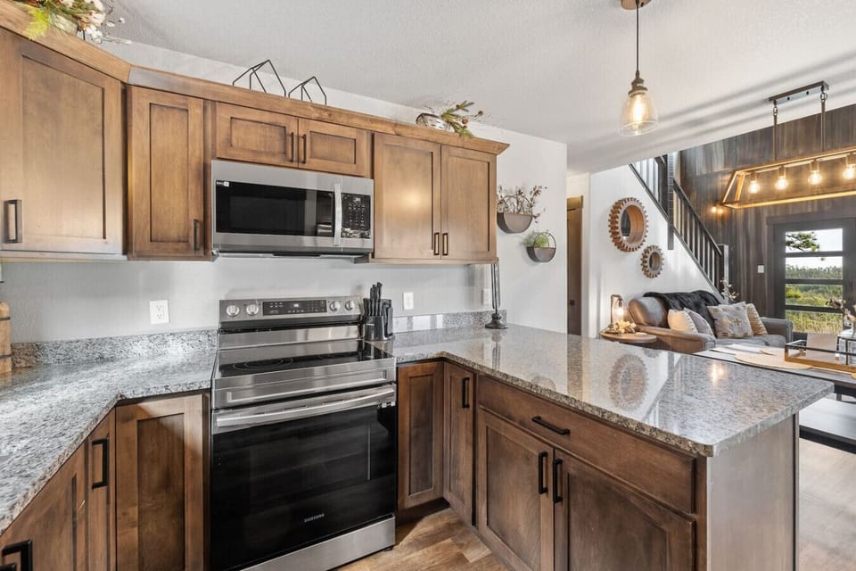 The kitchen boasts beautiful granite countertops and ample storage in attractive, medium-toned wood cabinets.