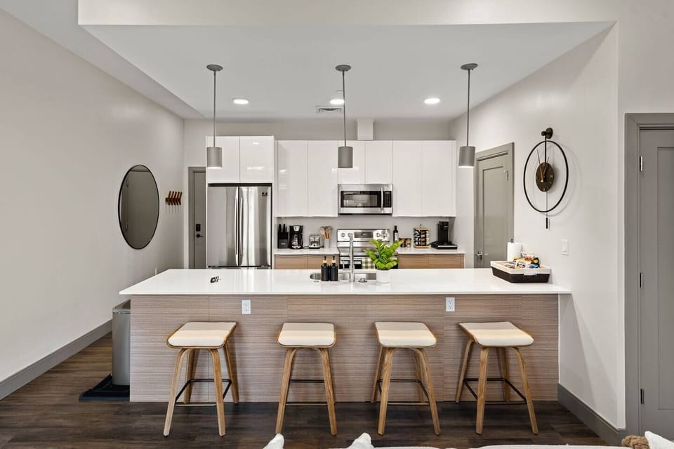 Sleek modern kitchen with appliances and a spacious island bar seating.