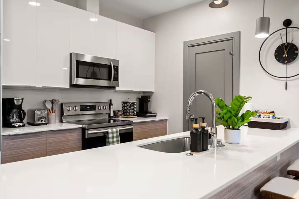 Modern kitchen island with a built-in stainless steel sink and faucet.