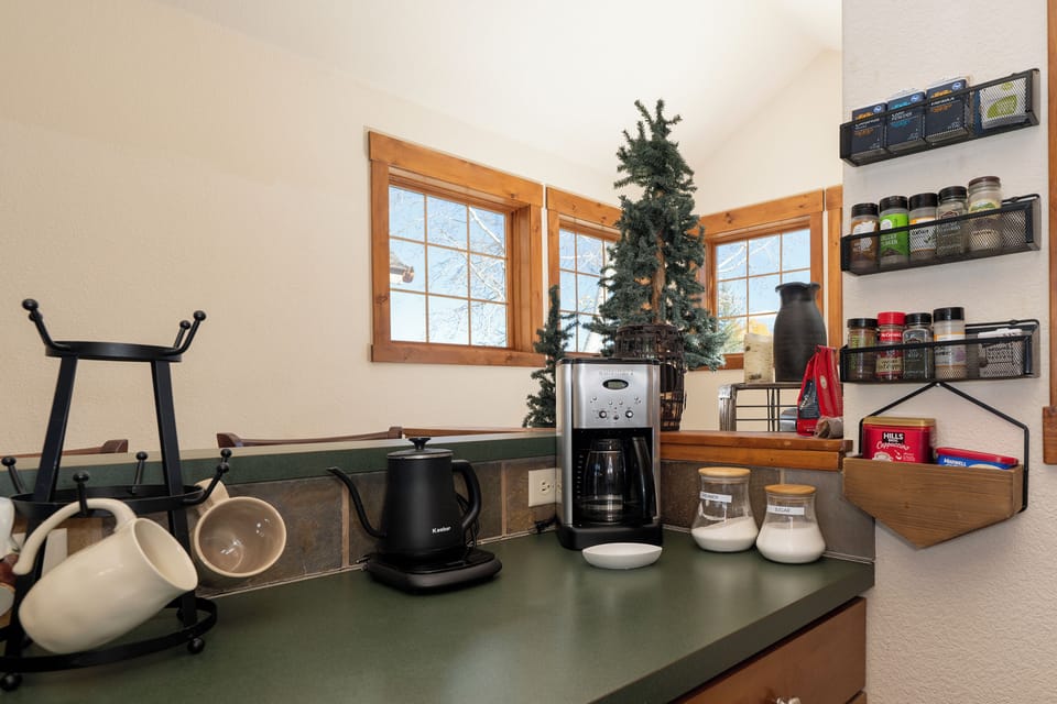 Your morning coffee ritual awaits with thoughtfully stocked shelves and warm natural light streaming through charming windows at Kicking Horse Palomino 7-302.