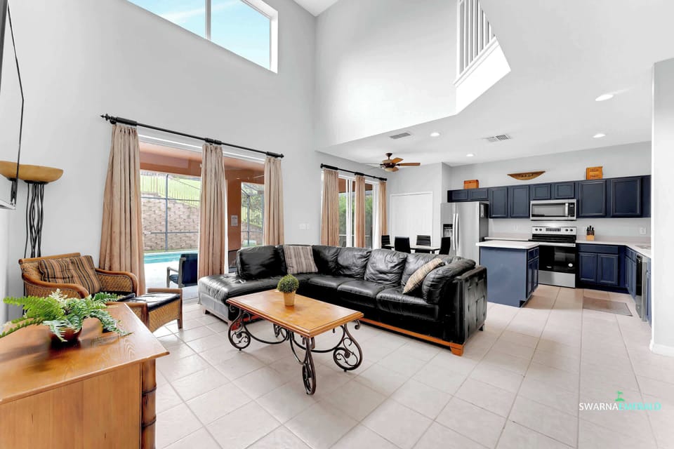 Unwind in this inviting living space with high ceilings and direct access to the outdoor pool area. 