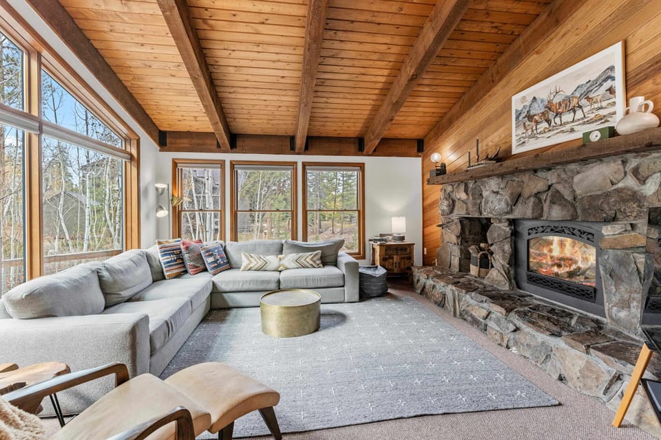 Relax by the fireplace in a cozy, sun-drenched living room with forest views!