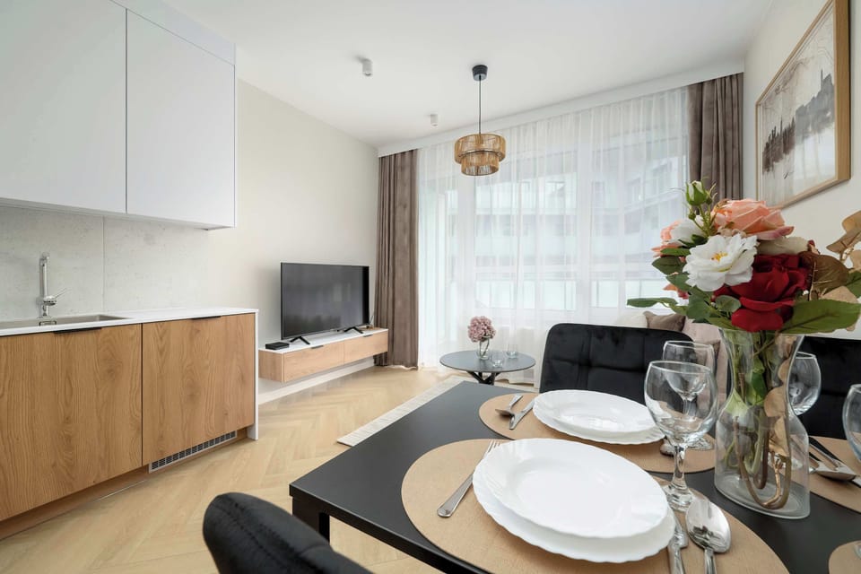 A spacious lounge area with a beige sofa and a black coffee table on a soft rug. The simple decor enhances comfort.