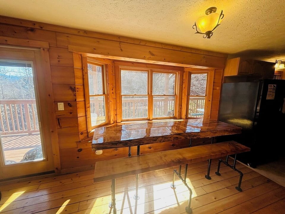 Gather around this rustic live-edge table in your warm cabin kitchen, where morning coffee and evening meals become cherished memories.