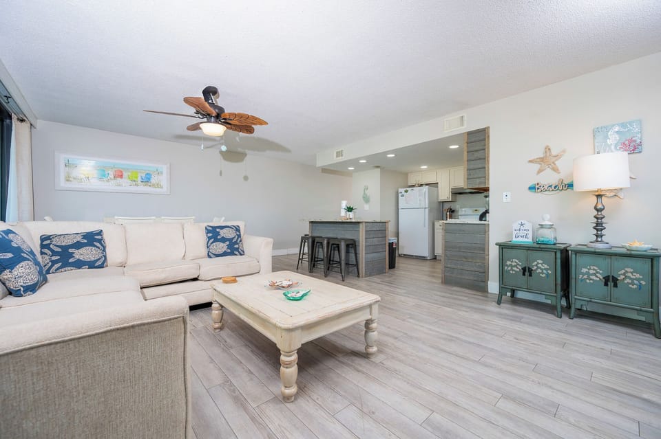 This inviting living area features a cozy couch, a charming coffee table, and a view of the well-equipped kitchen