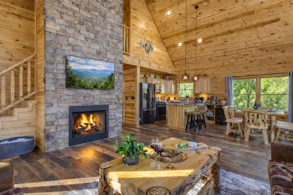 Spacious open-concept living room with a grand gas fireplace and smart TV, seamlessly connected to the kitchen and dining area—perfect for gathering everyone together.