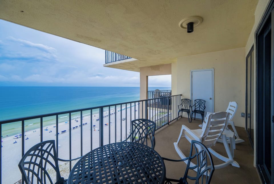 Relax on the balcony with a table and chairs, enjoying the serene beach view and gentle waves