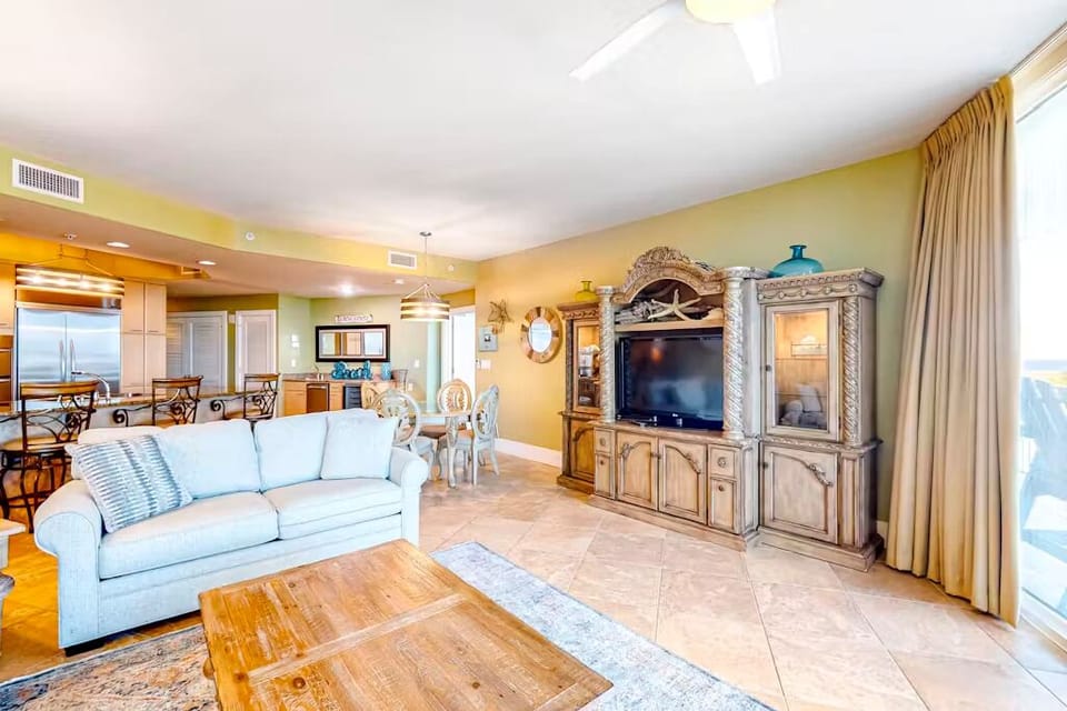 This inviting living area features a comfortable sofa, a TV, and a view of the beautiful bay, perfect for relaxation