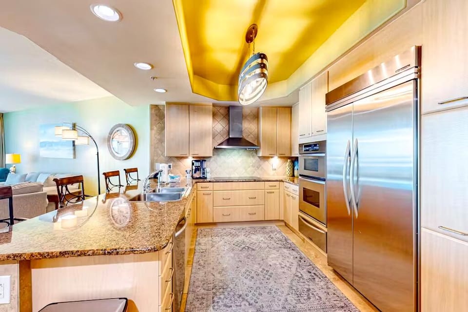 The kitchen features modern appliances and granite countertops with vibrant lighting, perfect for culinary adventures