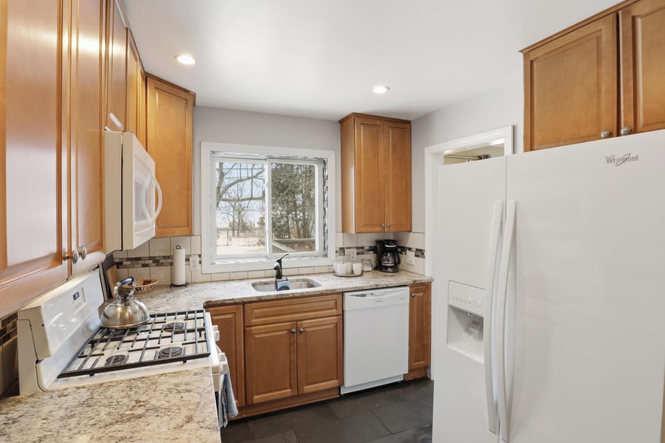 Kitchen has side entrance and stairs to basement laundry area.