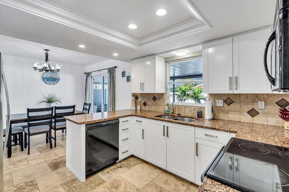 The kitchen has a light and airy feel to it from the bright lighting and white cabinetry.