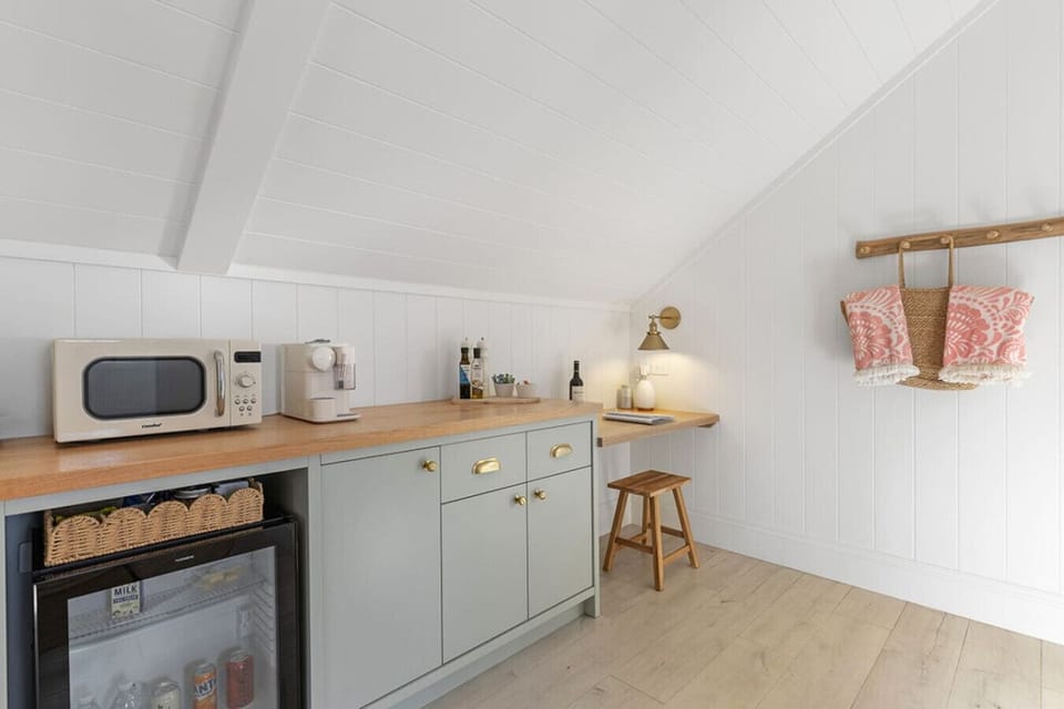 Self-contained kitchenette in The Barn with bar fridge, nespresso coffee machine, microwave, toaster and separate workstation with Bluetooth speaker.