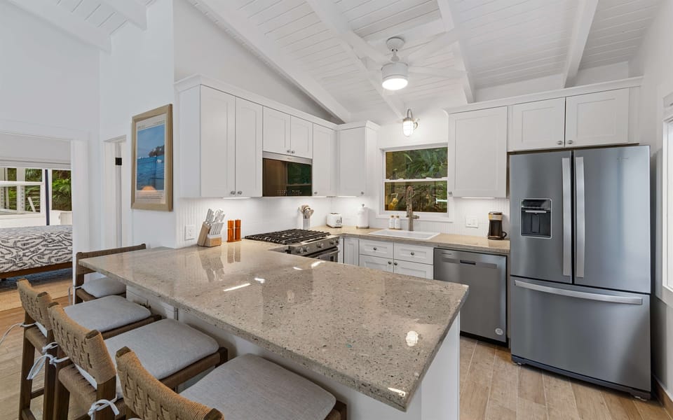 A wide kitchen island here offers plenty of room for guests to pull up a chair and keep the conversation going while the chef prepares a meal