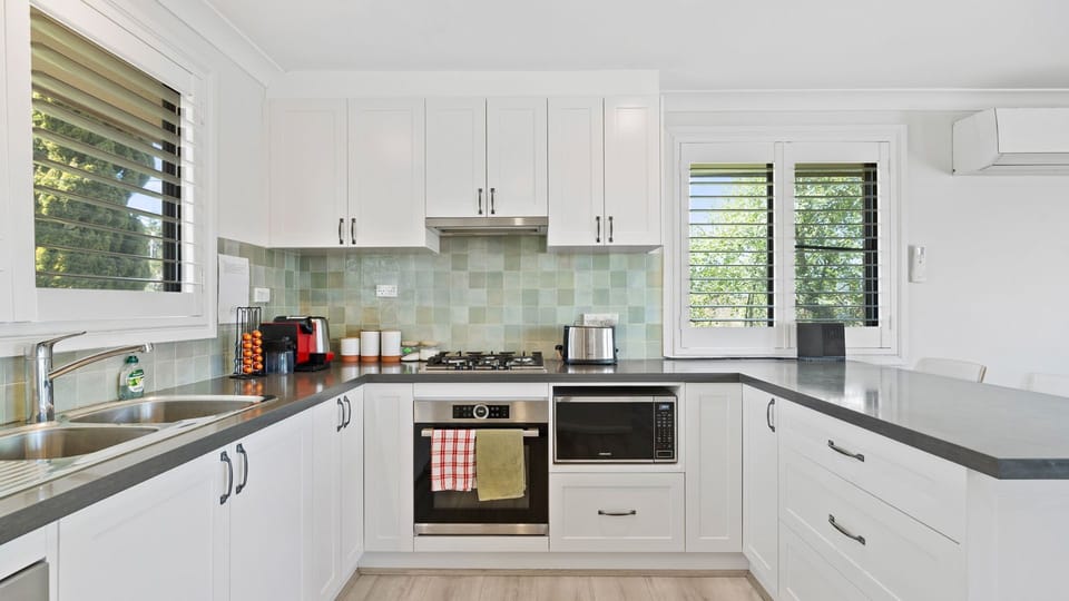 Spacious, fully equipped kitchen with ample storage and leafy window views