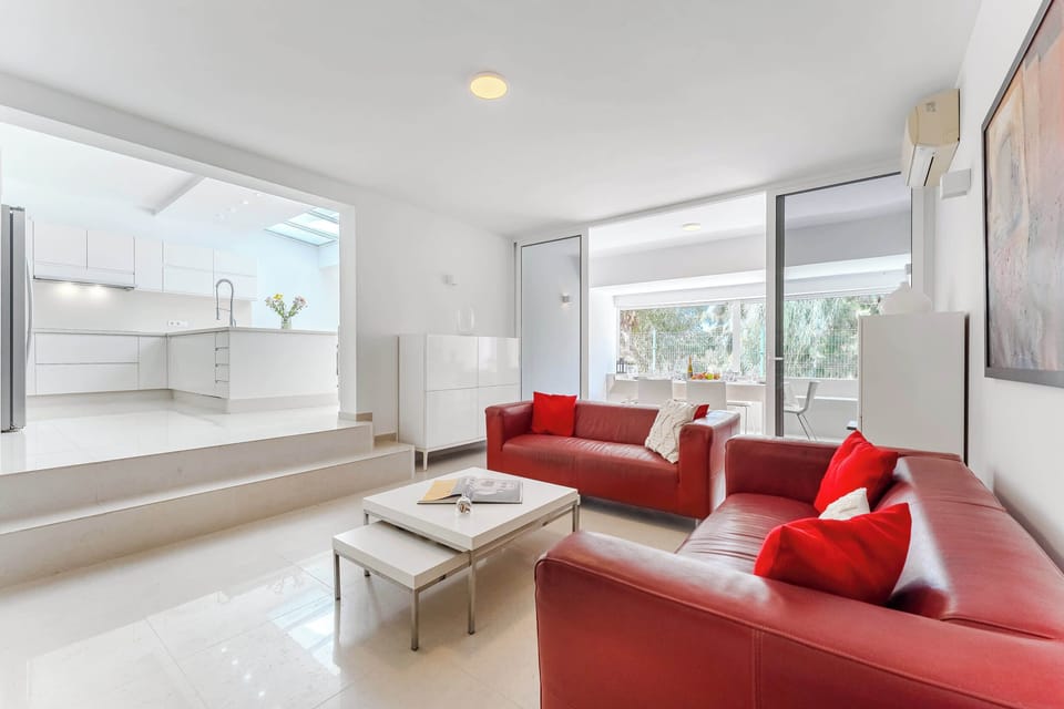 Bright Living Room with Bold Red Sofas, AC and Terrace Views – A Chic Lounge Space Designed for Comfort and Connection