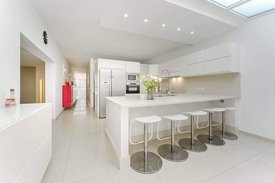 Sleek Minimalist Kitchen with Skylight, Breakfast Bar and Modern Appliances – Ideal for Effortless Home-Cooked Meals