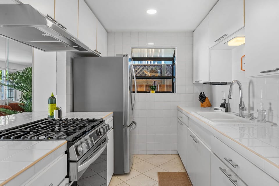 Kitchen with stainless stove + white tile