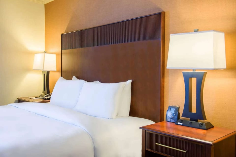 Cozy bed with wooden headboard and bedside lamp