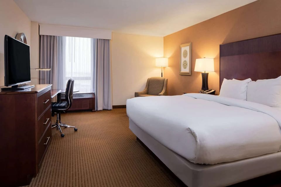 Spacious king room with desk, chair, and bright window