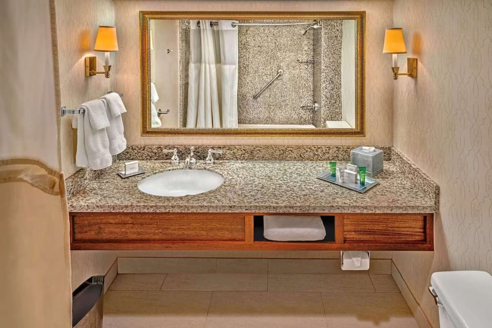 Bathroom with granite counter and large wall mirror