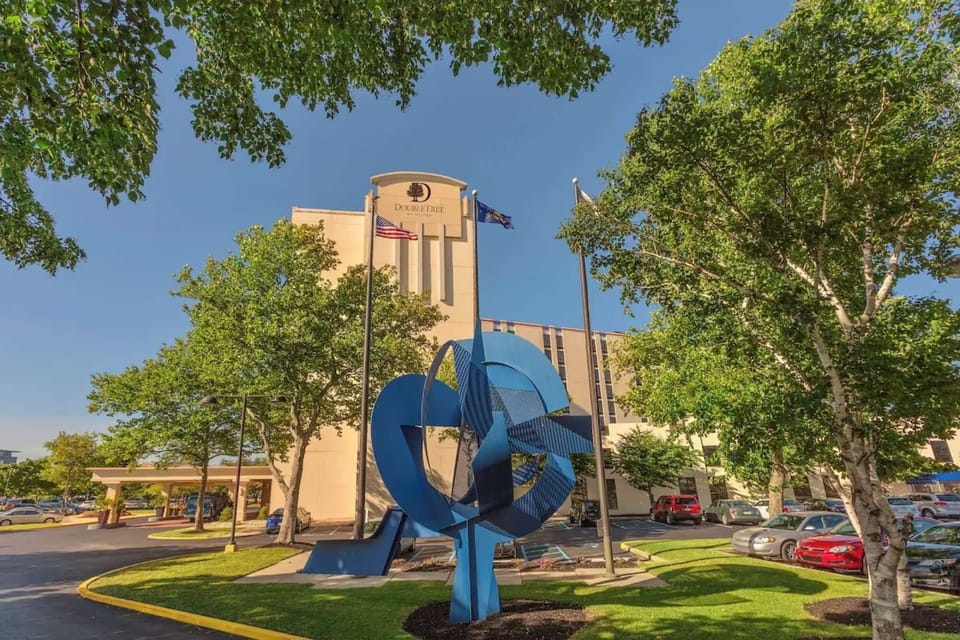 Front view with trees, flags, and blue sculpture art