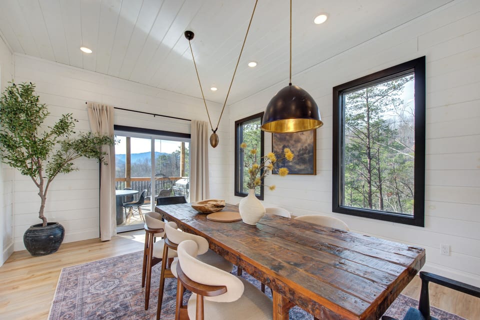 Gather around your rustic dining table where warm pendant lighting and mountain views create the perfect backdrop for memorable meals together.