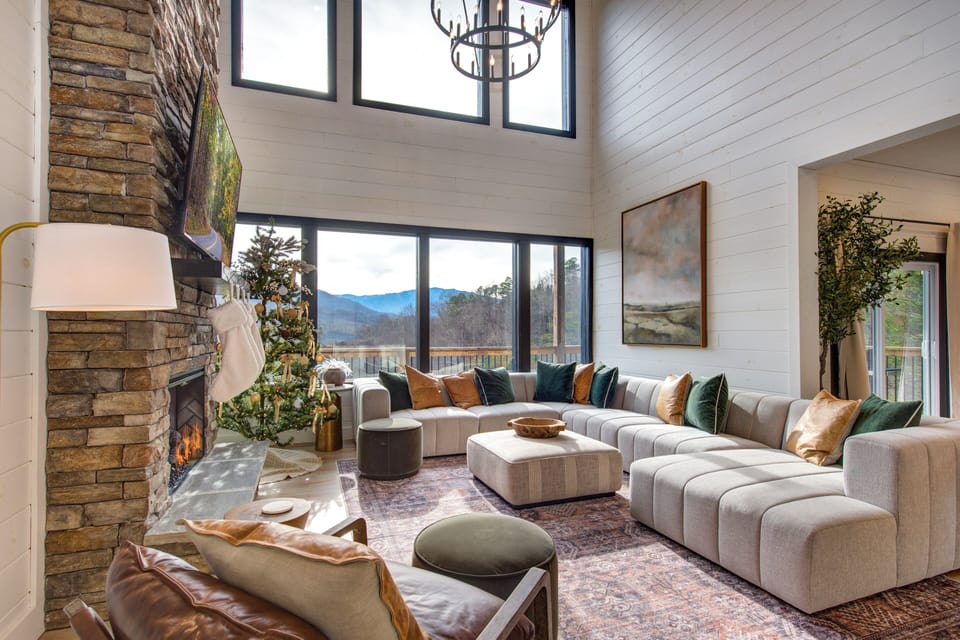 Sink into plush sectional seating by the crackling fireplace while mountain vistas frame your perfect retreat through floor-to-ceiling windows.