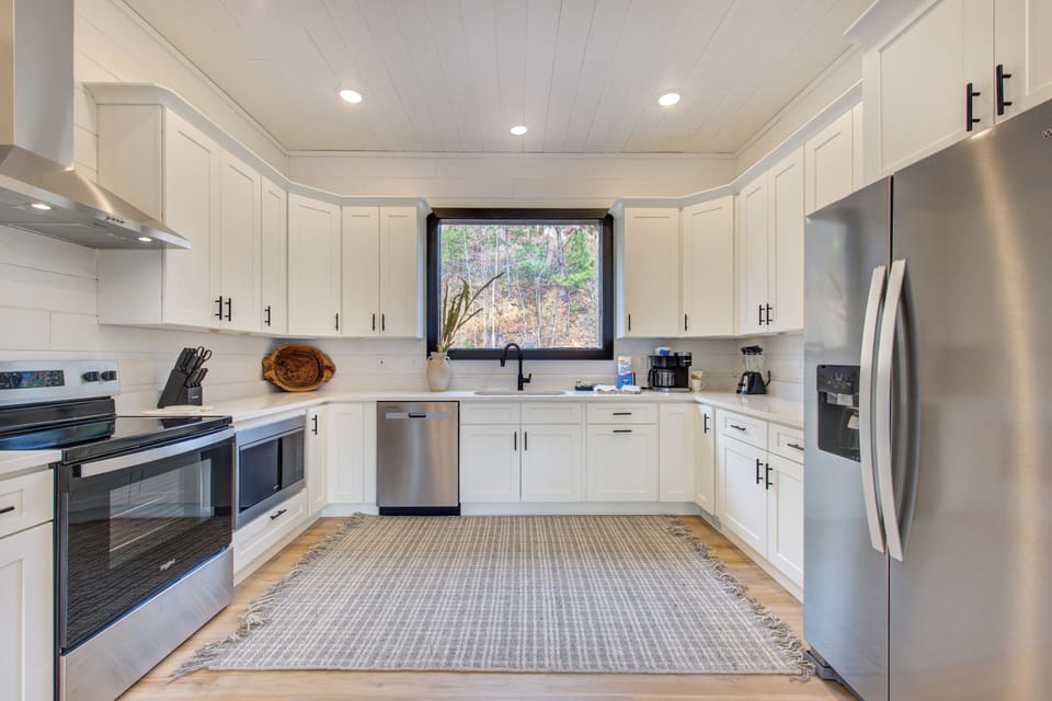 This bright, fully-equipped kitchen invites you to cook with friends. Stainless appliances, ample counter space, and a garden window create the perfect culinary retreat.