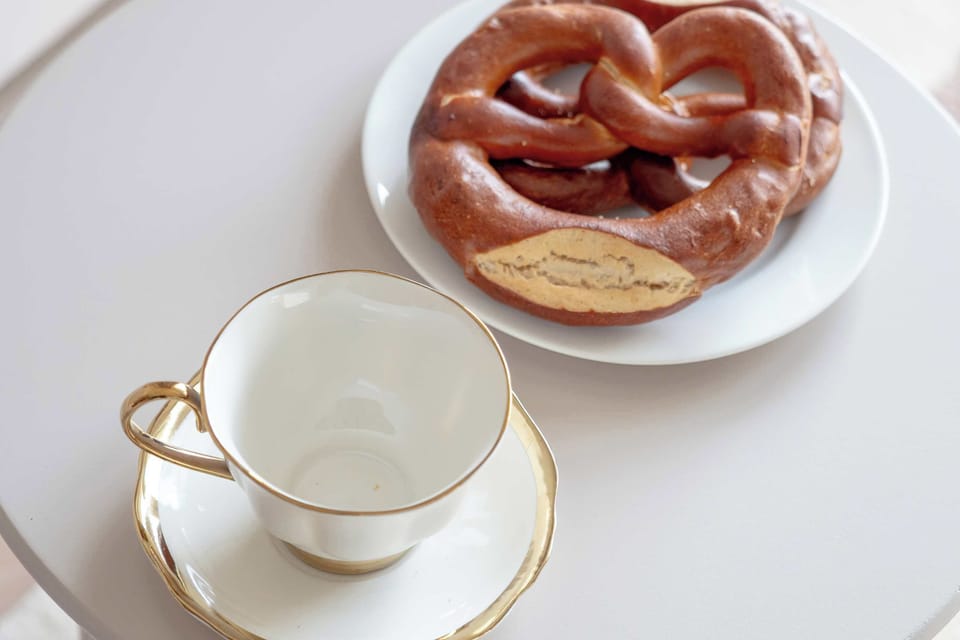 Close-up of breakfast setup with pastry, tea, and white teacup.