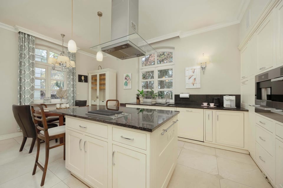 A corner of the kitchen with a small breakfast bar and high-end appliances. Glass-front cabinets provide extra light and openness.