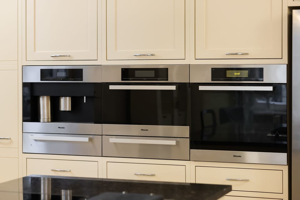 A modern kitchen with built-in appliances and sleek cabinetry. The neutral tones and clean design make it both stylish and practical.