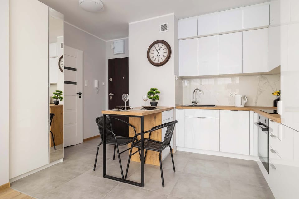 The modern kitchen cabinetry with white fronts and subtle lighting adds a sense of order and elegance.