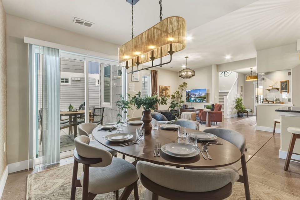 Your elegant dining space features warm wood tones and stylish lighting, opening to a private outdoor patio perfect for memorable meals.