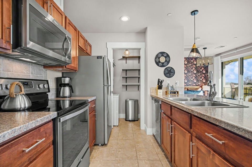 Your fully equipped kitchen awaits with stainless steel appliances, granite counters, and warm wood cabinets—perfect for preparing meals together.