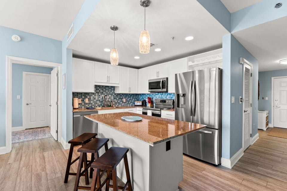 Spacious kitchen with granite countertops, pendant lighting, and a large island perfect for casual dining.