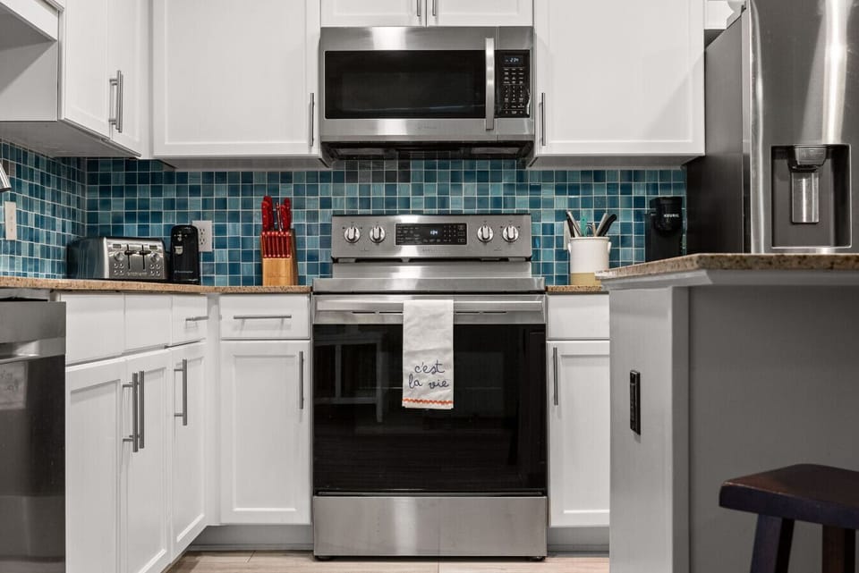 Stylish stainless-steel appliances and a modern backsplash make this fully equipped kitchen a chef’s dream.
