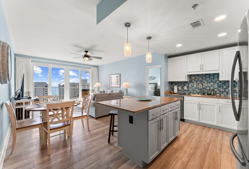 nviting open-floor plan showcasing a modern kitchen, island seating, and views of the gulf beyond.